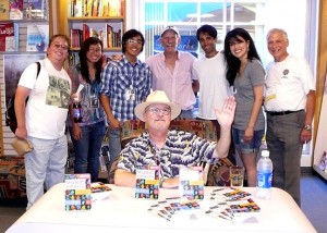 Here I am, surrounded by my book-signing event team and waving at the curious crowd.  Class Reunion.  Photo by Sandy Pritzker.